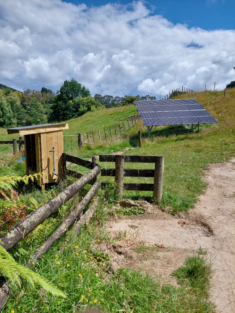Rural property track leading to off-grid solar pump array